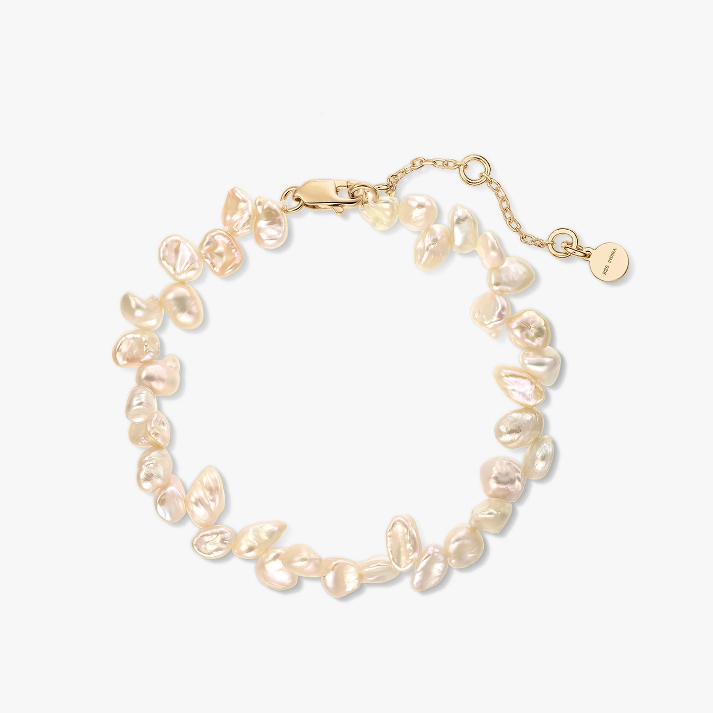 Gold‑plated sterling silver bracelet with natural pink keshi pearls and extender chain on a white background.