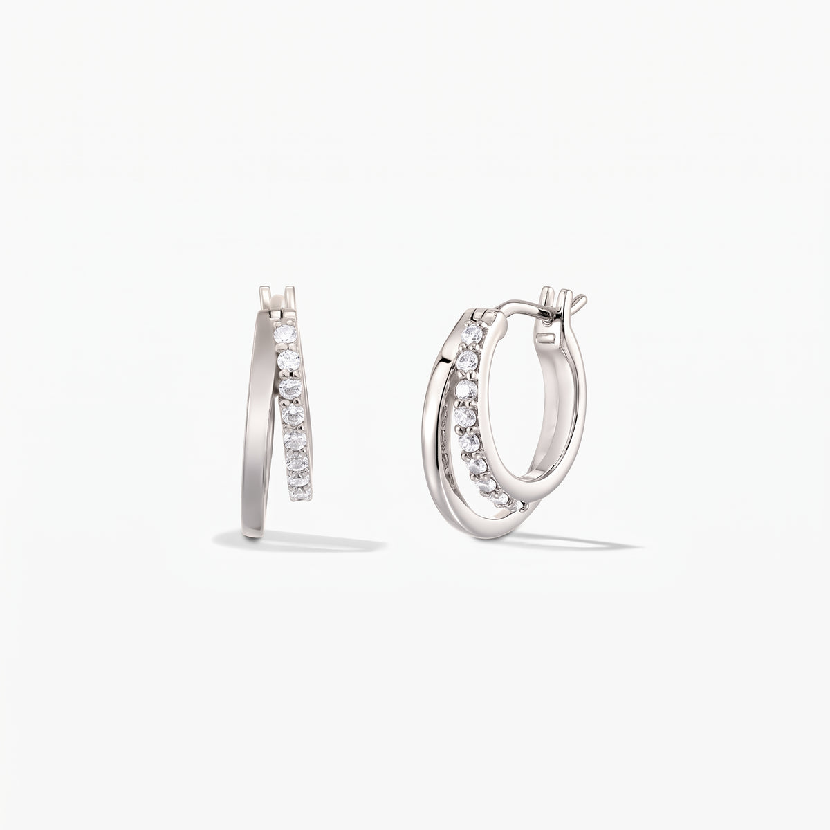 Pair of Siamese silver double-hoop earrings with pavé zirconia on a white background.