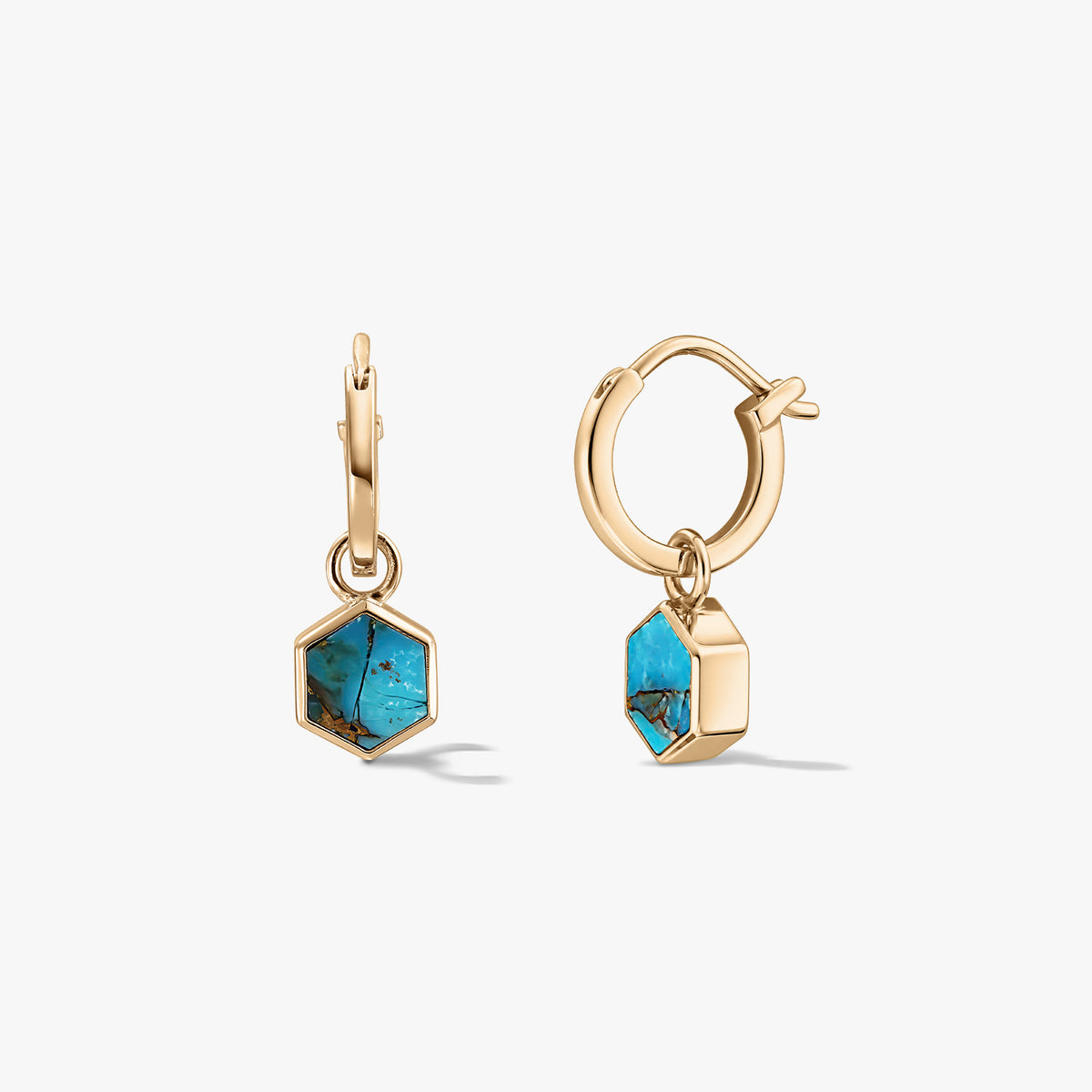 Pair of small gold‑tone huggie hoop earrings with hexagon turquoise blue‑copper stone charms on a white background.