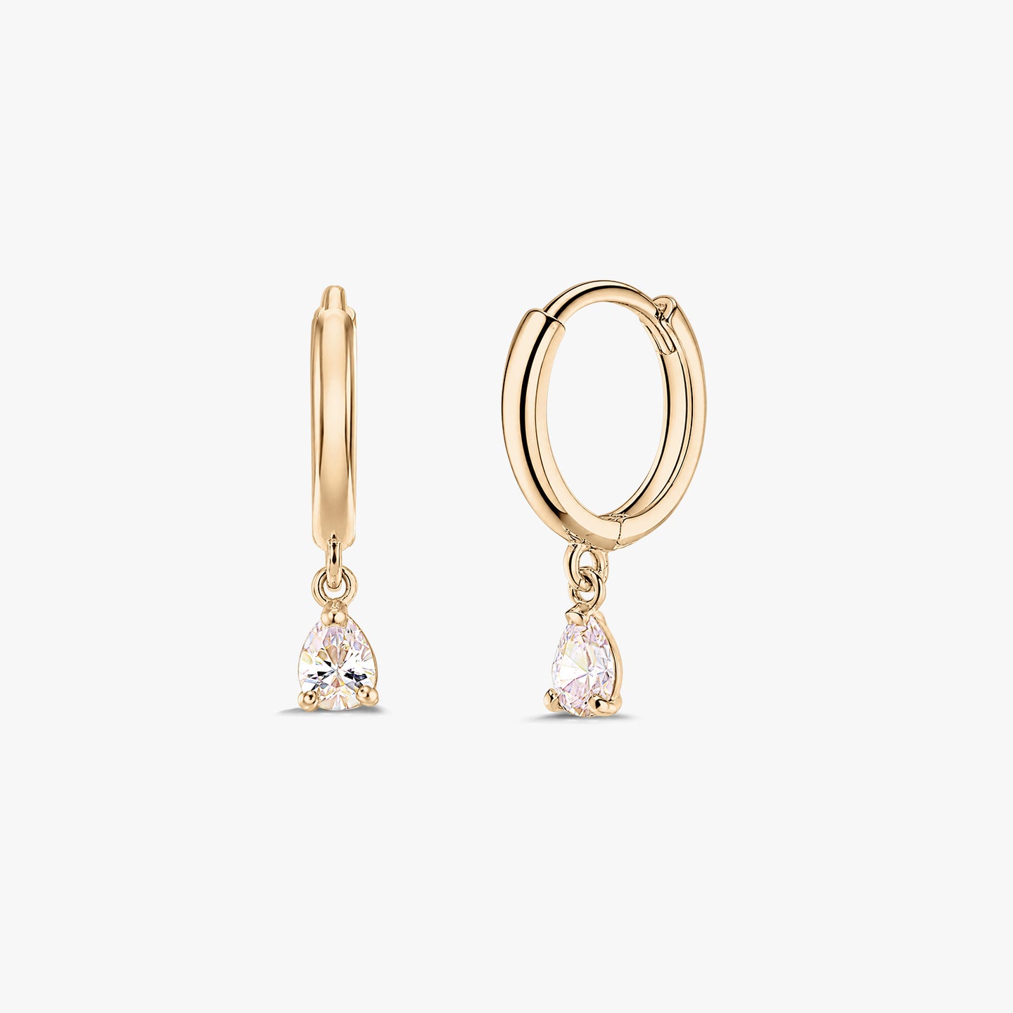 Pair of 14K yellow gold huggie hoop earrings with dangling pear-cut white zirconia drops on a white background.