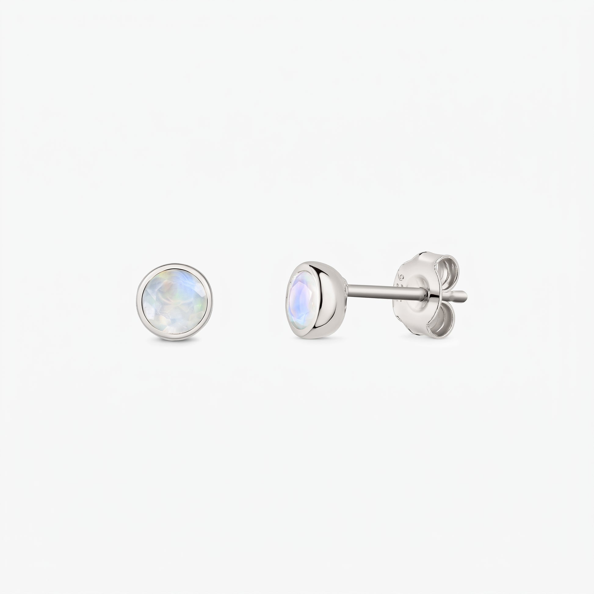 Pair of 925 sterling silver moonstone stud earrings on a white background, shown front and side with butterfly backs and bezel-set round iridescent stones.