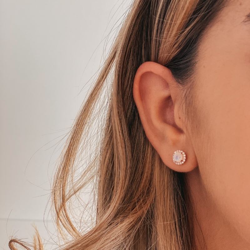 Close-up of a person's ear wearing a Keira Rose Silver Earring with Moonstone on a light background.