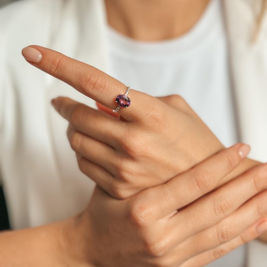 Közelkép egy kézről, amelynek mutatóujján egy Amethyst és Cirkónia kövekkel díszített Reina ezüstgyűrű látható.