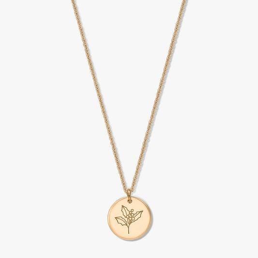 Gold‑plated sterling silver necklace with a round disc pendant engraved with a holly (December birth flower) motif on a white background.
