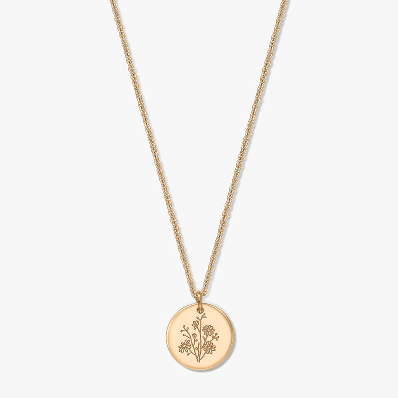 Gold-plated silver necklace with a delicate rope chain and round coin pendant engraved with an aster birthflower, isolated on a white background.