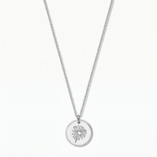 Sterling silver necklace with a round disc pendant engraved with a daisy, photographed on a white background.