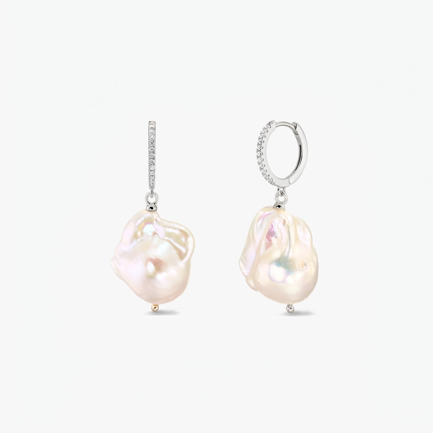 Pair of rhodium‑plated 925 silver hoop earrings with pavé zirconia and large organic baroque pearls on a white background.