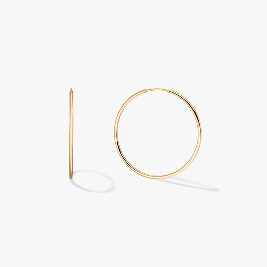 A pair of gold hoop earrings displayed on a white background.