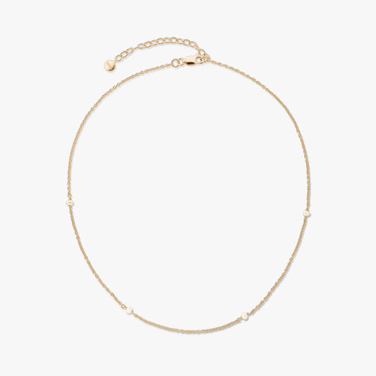 Delicate gold‑plated 925 silver necklace with tiny natural pearls and an adjustable extender with lobster clasp on a white background.