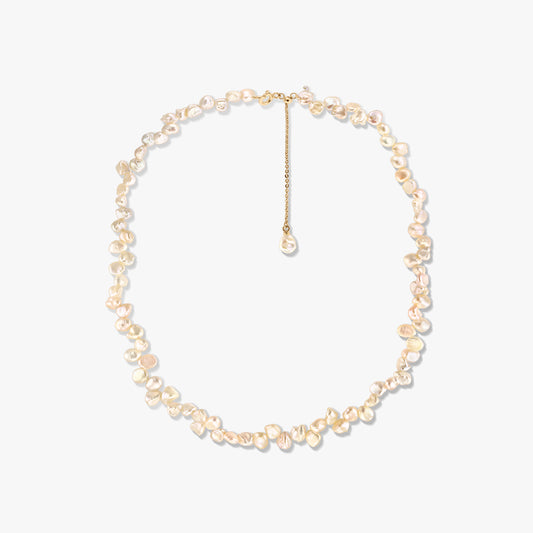 Gold‑plated silver necklace with irregular pink keshi pearls and an adjustable extender, photographed on a white background.