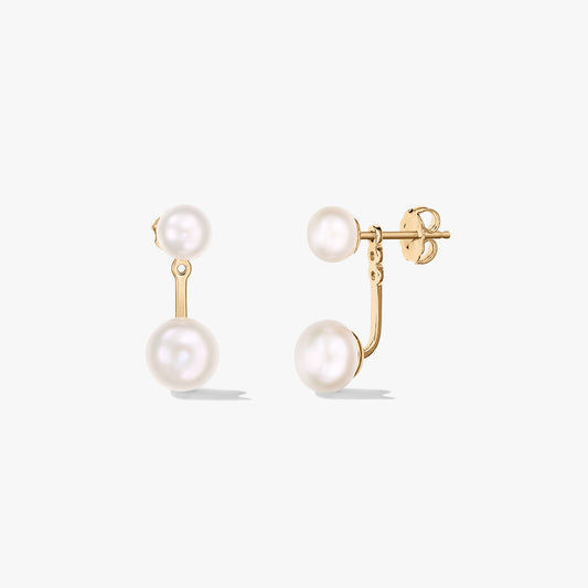 Egy pár aranyozott sterling ezüst ear‑jacket stift fülbevaló természetes fehér gyöngyökkel, fehér háttéren — elölnézet és oldalnézet pillangózárral.