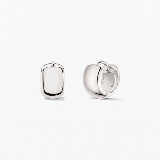 Indira Bold Mini Hoops ezüst karika fülbevalók 925-ös sterling ezüstből, fehér háttéren. Az egyik fülbevaló elölnézetben, a másik oldalnézetben látható, a csuklós kapocs jól kivehető.