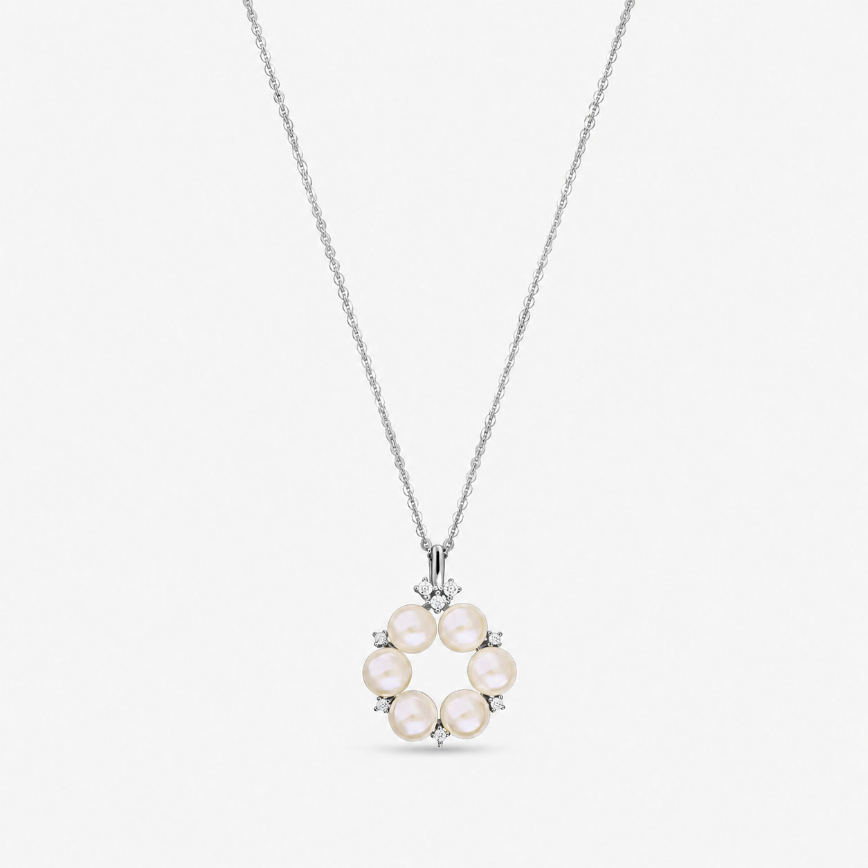Sterling silver necklace with a circular pendant of six natural pearls accented by small white zirconia, shown on a fine chain against a white background.
