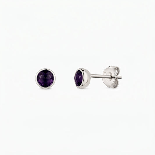 Pair of sterling silver stud earrings with round faceted amethyst stones, bezel-set, shown front and side on a white background.