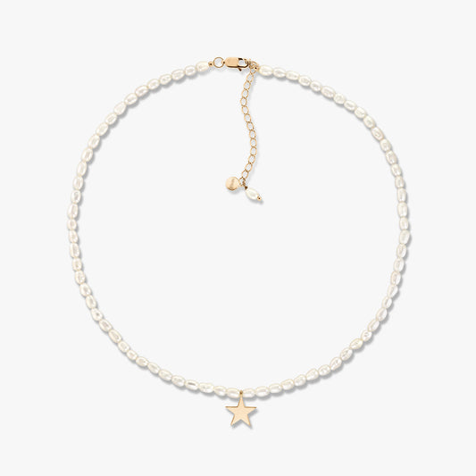 Delicate cultured pearl beaded necklace with a small gold star pendant and an adjustable gold extender, shown on a white background.
