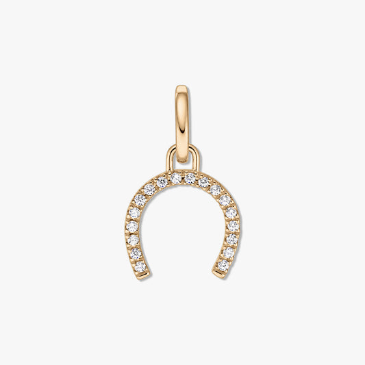 Gold-tone horseshoe silver pendant with pavé clear zirconia stones on a white background.