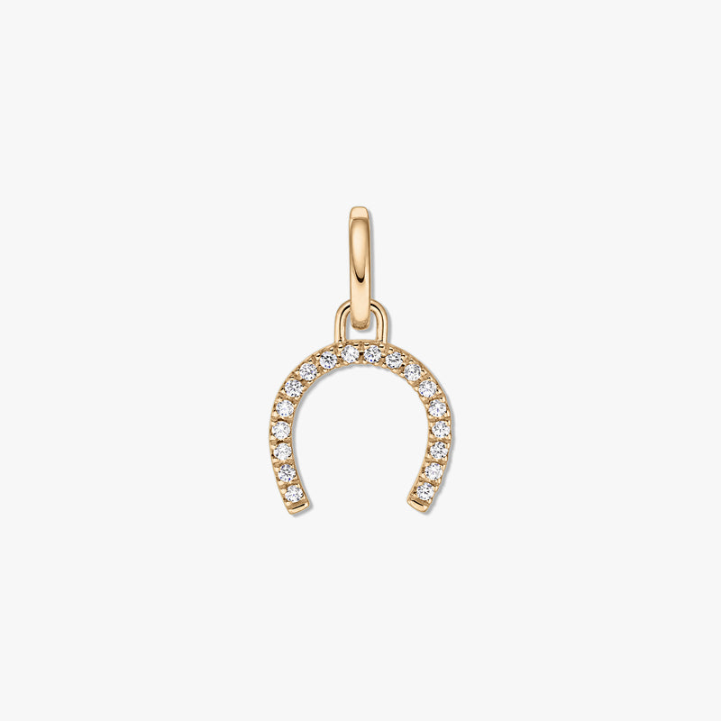 Golden horseshoe silver pendant set with clear zirconia stones on a white background.