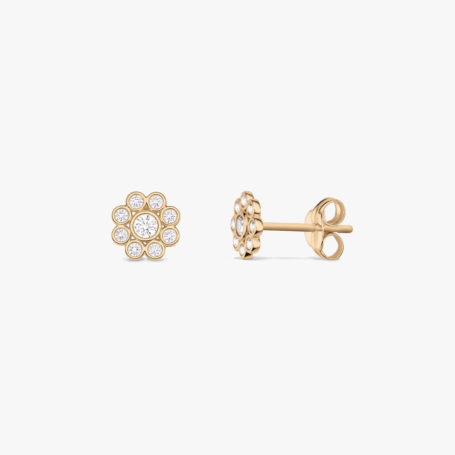 Pair of daisy-shaped 14K yellow gold stud earrings with white cubic zirconia, shown front and side on a white background.