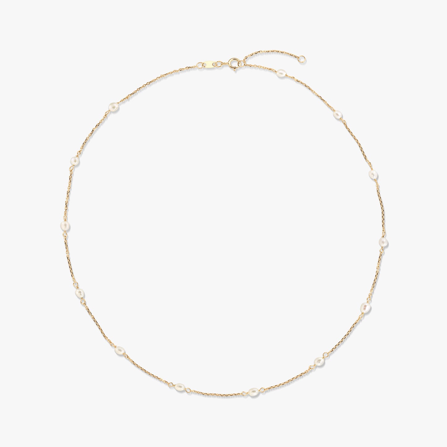 Elegáns 14K sárga arany station nyaklánc, apró, természetes fehér gyöngyökkel a finom láncon egyenletesen elhelyezve, fehér háttéren.