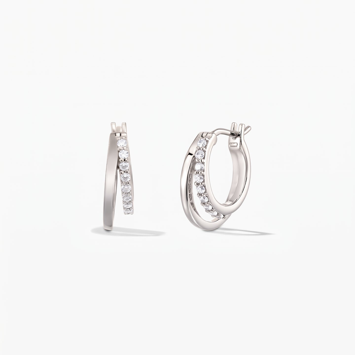 Pair of Siamese silver double-hoop earrings with pavé zirconia on a white background.
