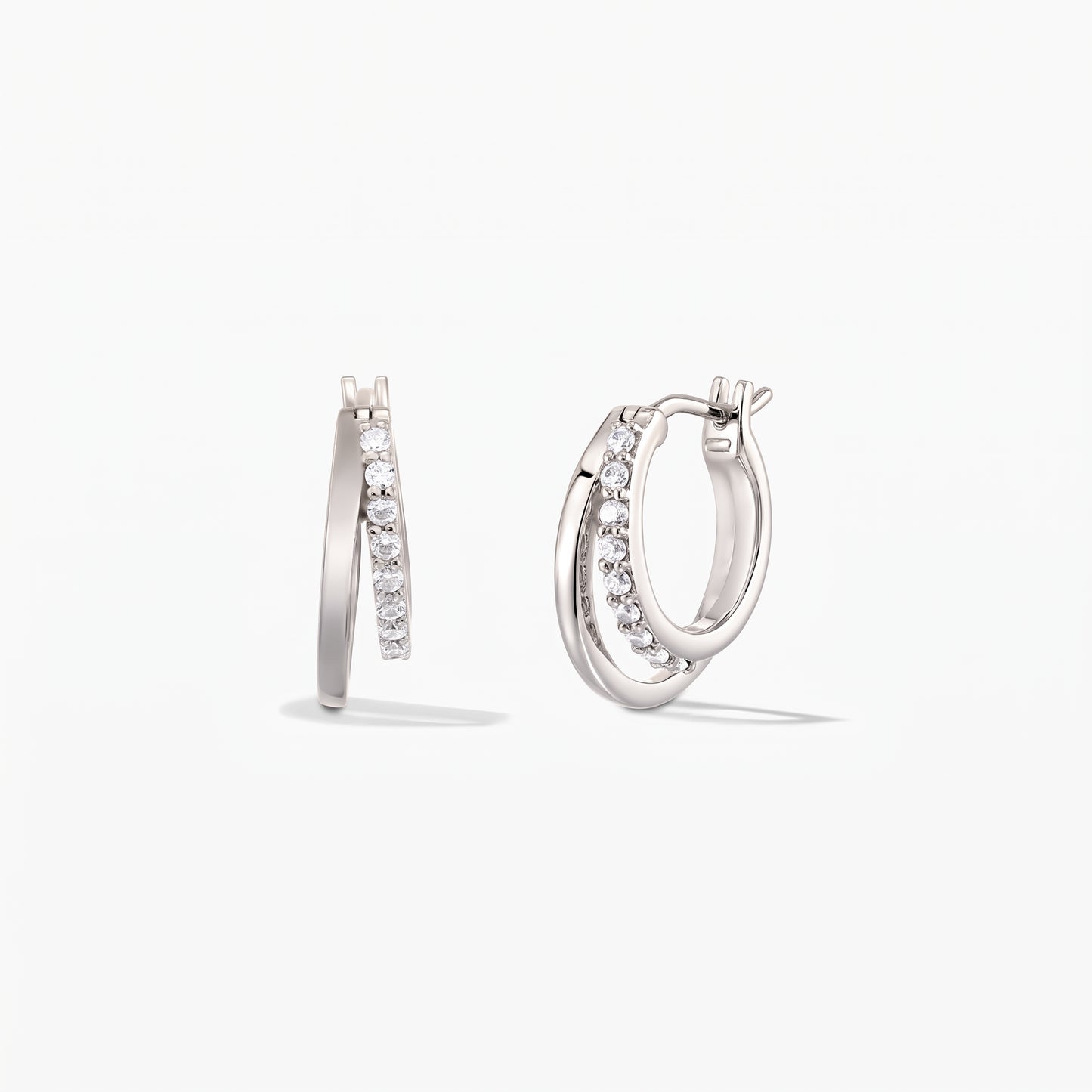 Pair of Siamese silver double-hoop earrings with pavé zirconia on a white background.