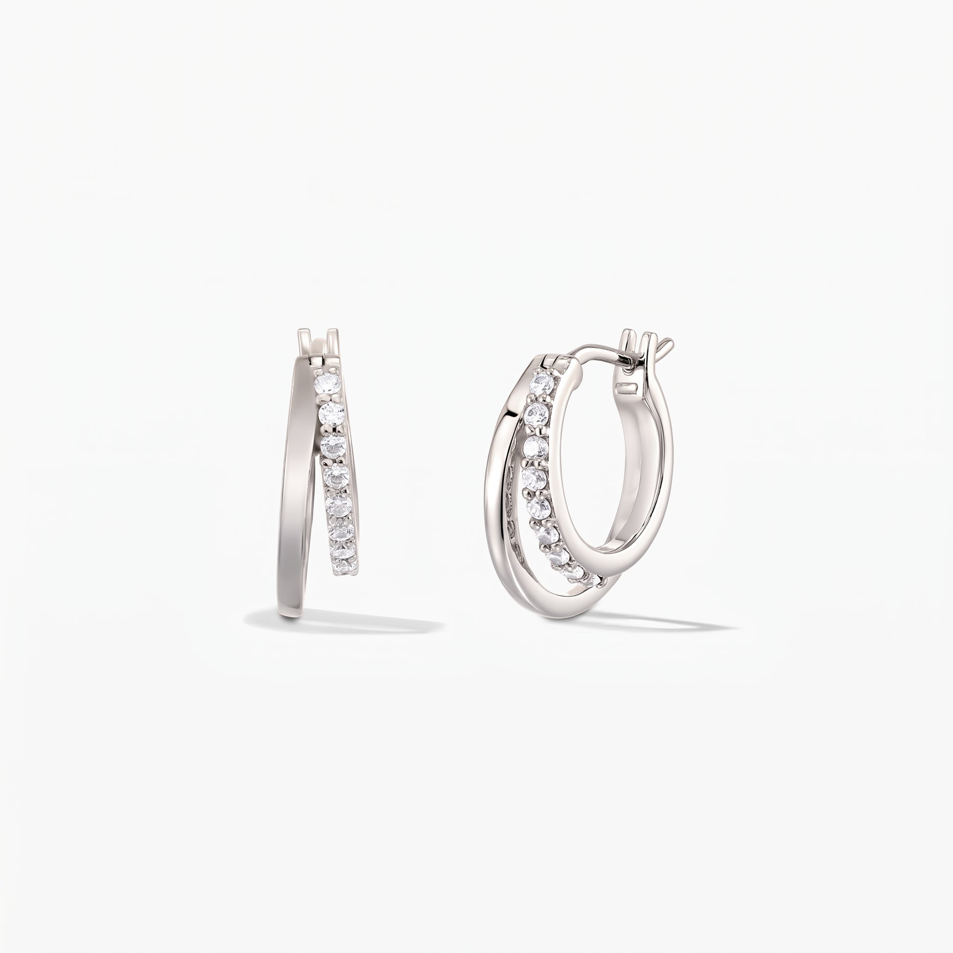 Pair of Siamese silver double-hoop earrings with pavé zirconia on a white background.