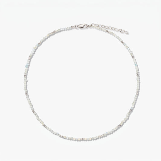 Dainty sterling silver necklace with small moonstone beads and an adjustable extender chain, photographed on a white background.
