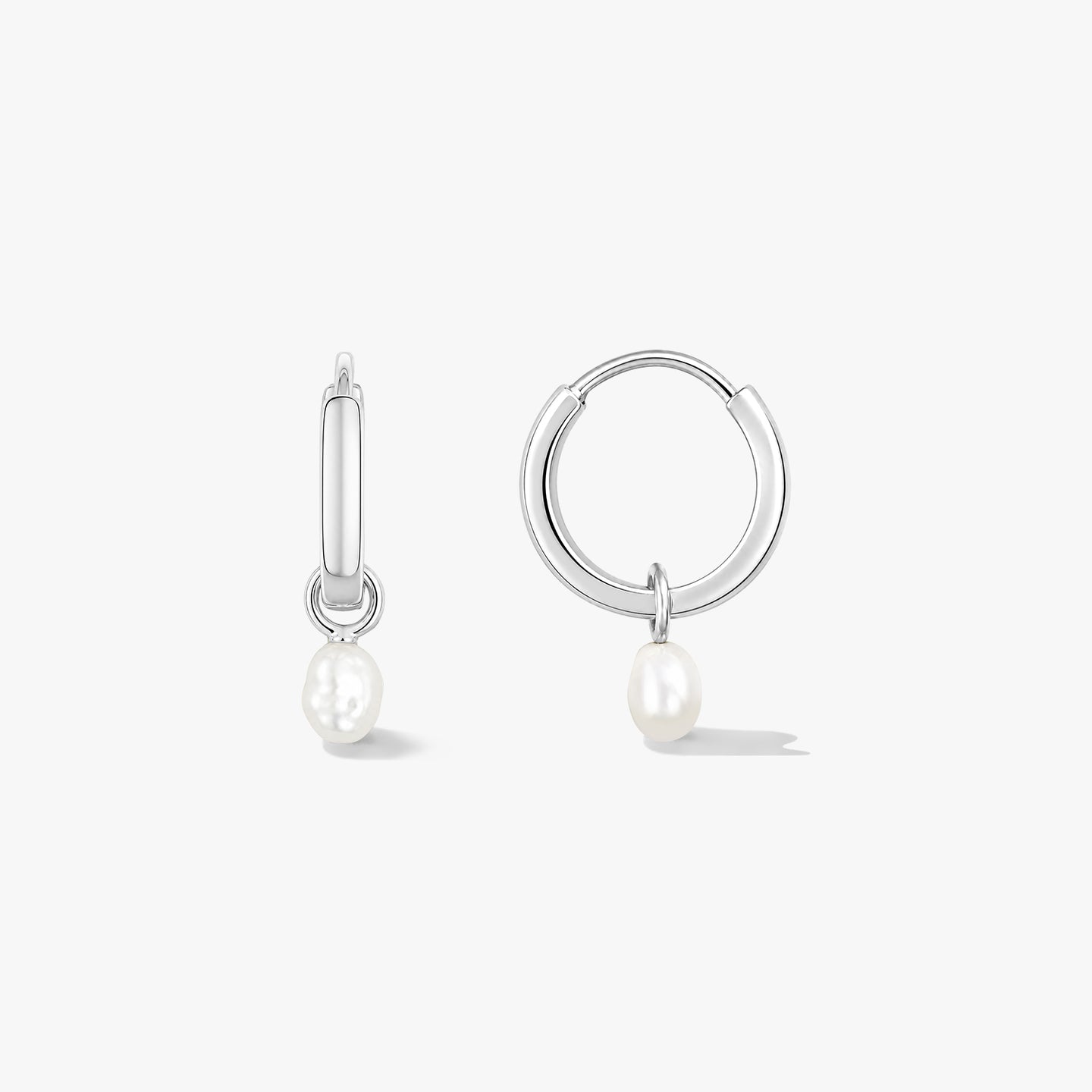 Pair of sterling silver hoop earrings with small natural pearl drops on a white background, one shown front-facing and one in side view.