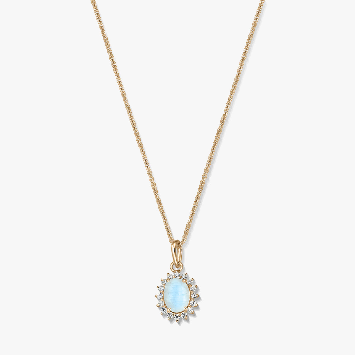Gold‑plated sterling silver necklace with an oval light‑blue moonstone pendant framed by small clear stones on a white background.