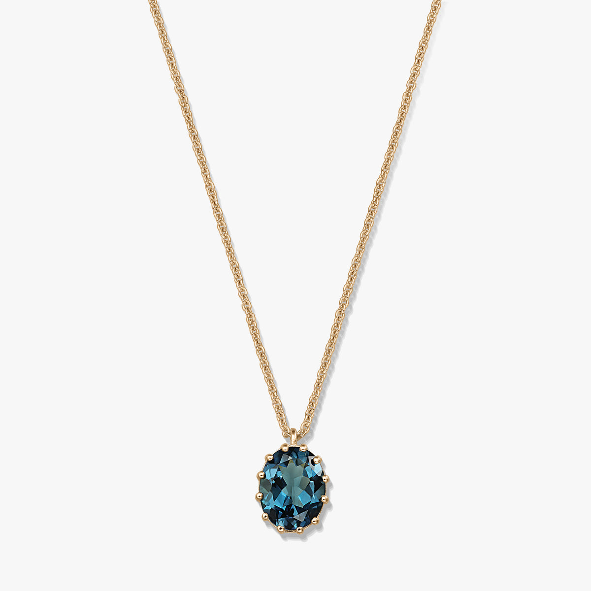 Delicate gold‑plated sterling silver necklace with an oval London blue topaz pendant on a white background.