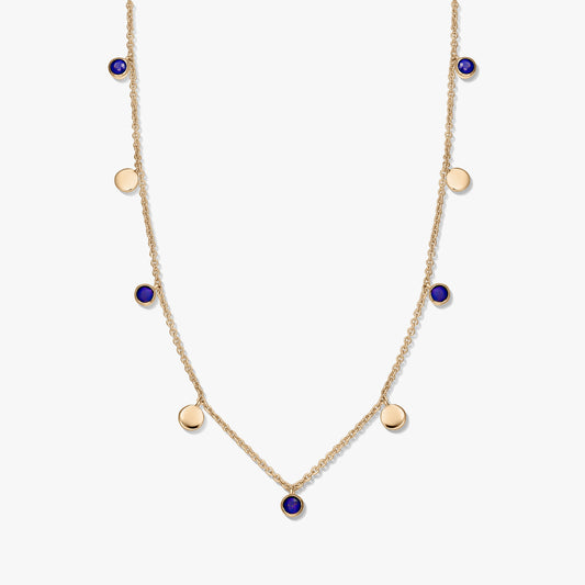 Gold‑plated sterling silver station necklace with round lapis lazuli cabochons and small gold disc charms on a delicate chain, photographed on a white background.