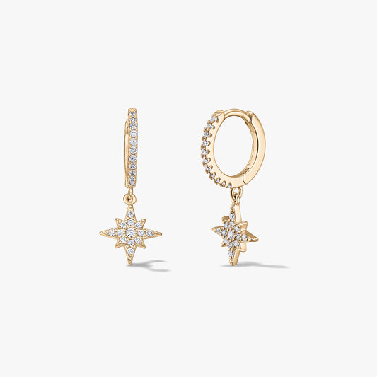 Pair of gold-plated silver huggie hoop earrings with pavé zirconia starburst charms on a white background.
