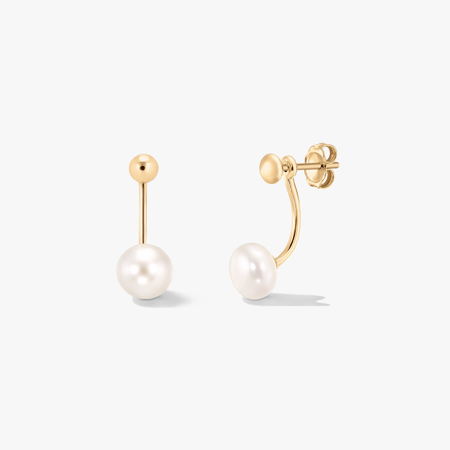 Egy pár aranyozott sterling ezüst ear jacket fülbevaló természetes fehér gyöngyökkel, tiszta fehér háttéren.
