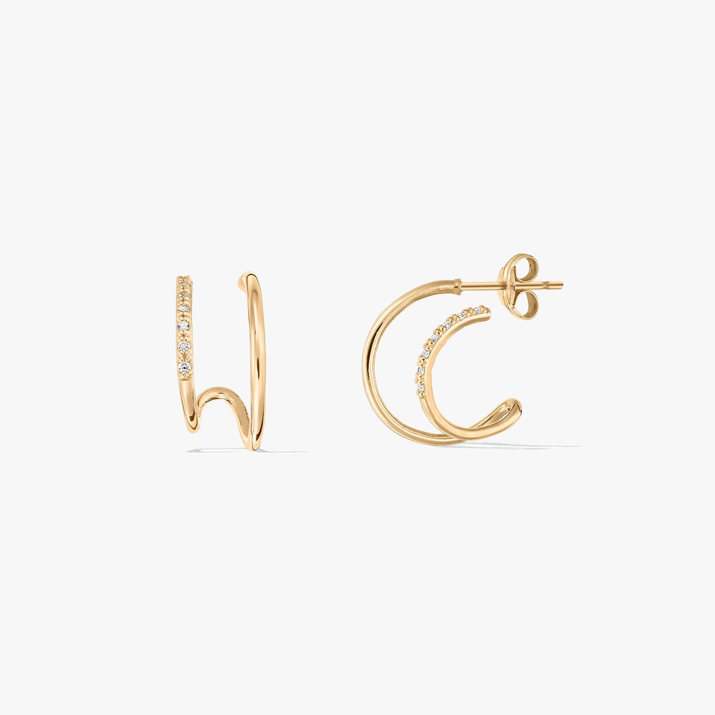 Pair of gold double hoop earrings with embedded stones on a white background.