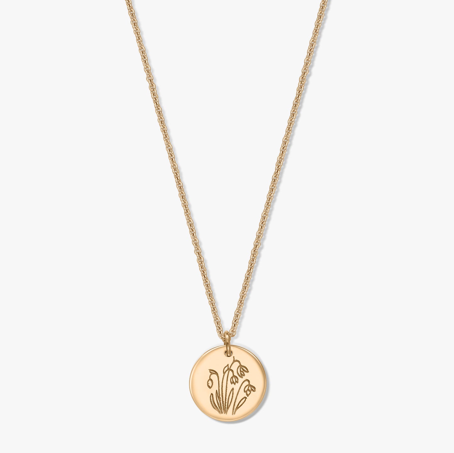 Gold‑plated sterling silver necklace with a round disc pendant engraved with the January birth flower snowdrop, shown on a white background.