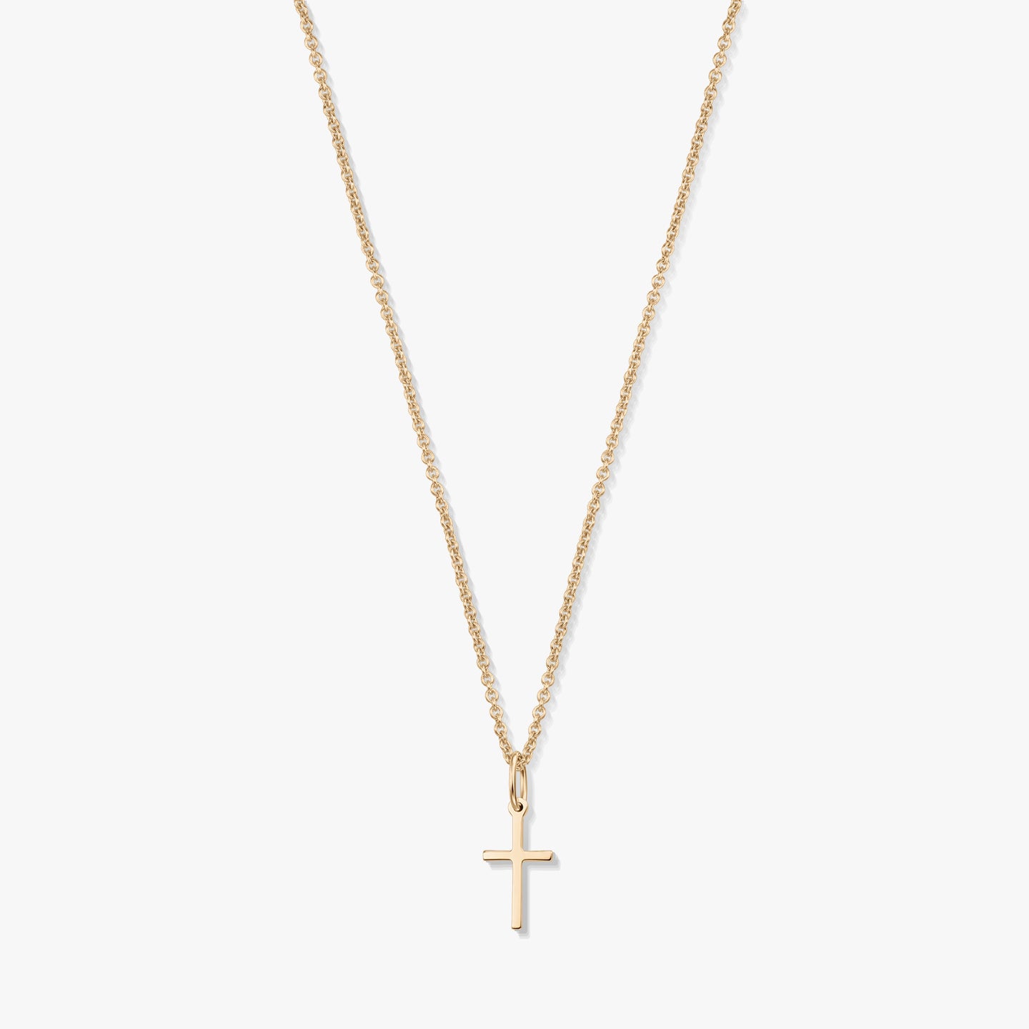 Minimalista 14K sárga arany nyaklánc apró kereszt medállal, finom láncon, fehér háttéren.
