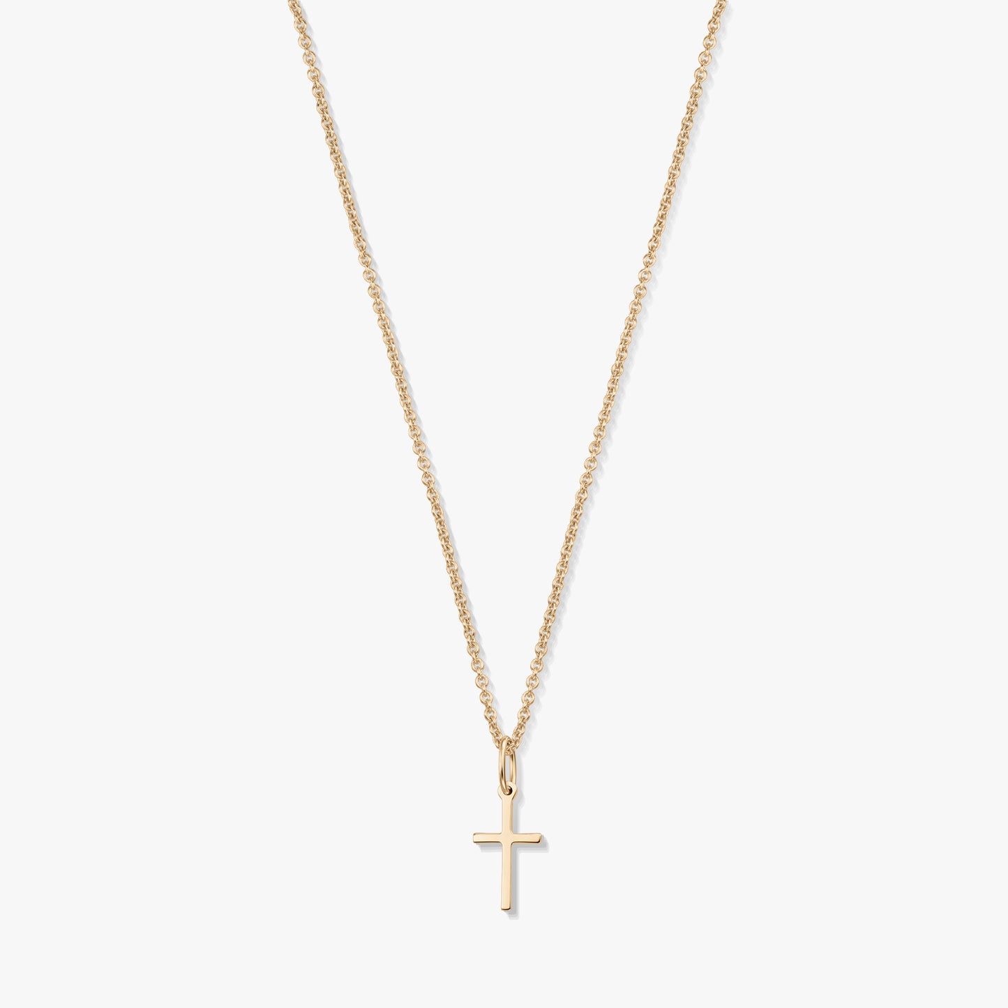 Minimalista 14K sárga arany nyaklánc apró kereszt medállal, finom láncon, fehér háttéren.
