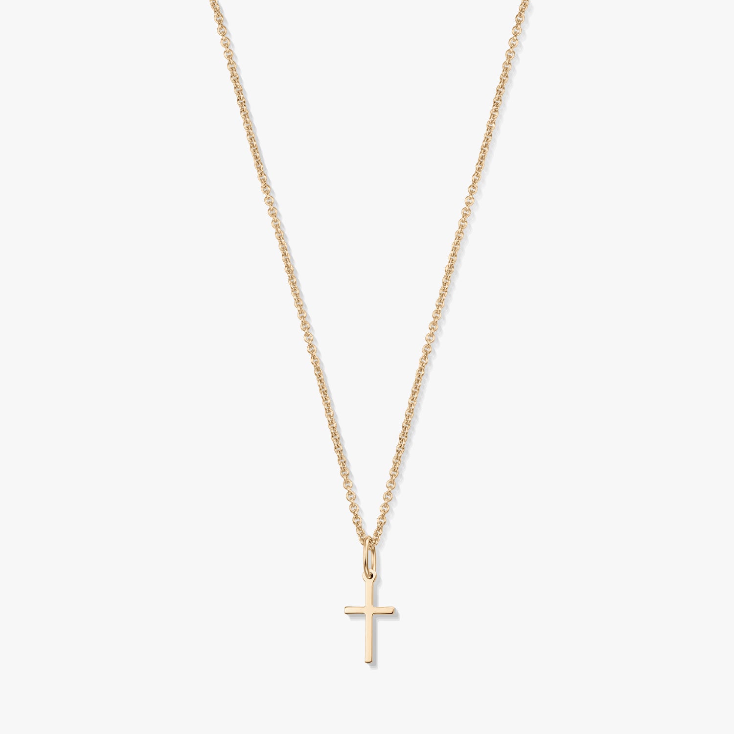 Minimalista 14K sárga arany nyaklánc apró kereszt medállal, finom láncon, fehér háttéren.