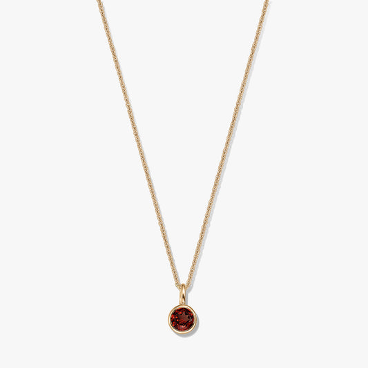 Gold‑plated sterling silver birthstone necklace with a round bezel‑set garnet pendant on a delicate chain, isolated on a white background.