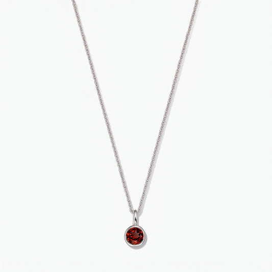 Sterling silver birthstone necklace with a round bezel‑set garnet pendant on a white background.