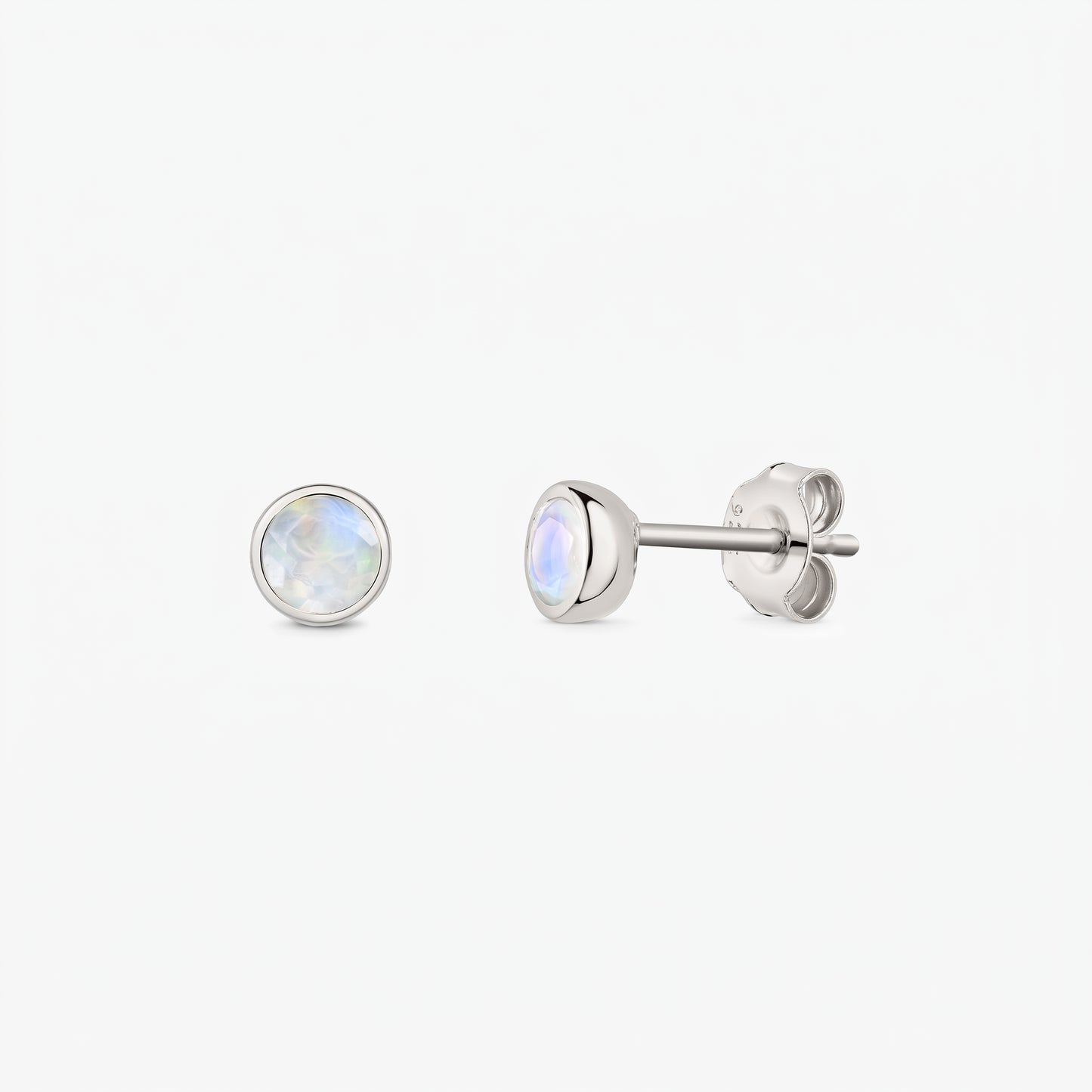 Pair of 925 sterling silver moonstone stud earrings on a white background, shown front and side with butterfly backs and bezel-set round iridescent stones.